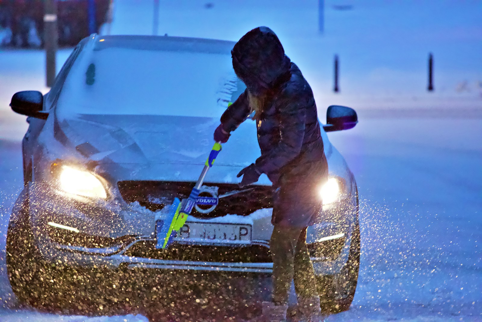 man in brown jacket riding blue snow sled during daytime